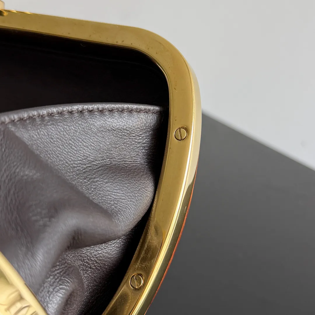 Batch 2720 BOTTEGA VENETA2025 new kont evening bag When the natural texture of wood meets the brass edge, the BV evening bag becomes a work of art in the fashion world. Every wood grain is a mark of time, delicate and unique. The brass metal buckle is embellished like stars, and opening it is full of ritual. It is the focus of the dinner party, and can easily store your exquisite small things. The warmth of wood and the cold and cool collision of metal tell the niche light luxury style in every gesture, allowing you to shine with a unique attitude in every feast. Style number: 804292 (717622) Color: maroon Size: 20.5*6*12.5cm